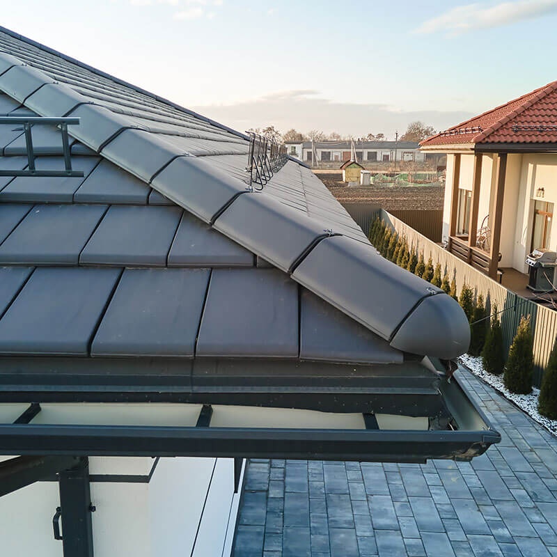 Technician cleaning blocked gutters on a house in Plymouth